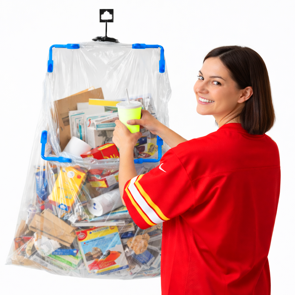 A woman in a red shirt is disposing of a cup into a large hanging trash bag holder filled with recyclable waste.